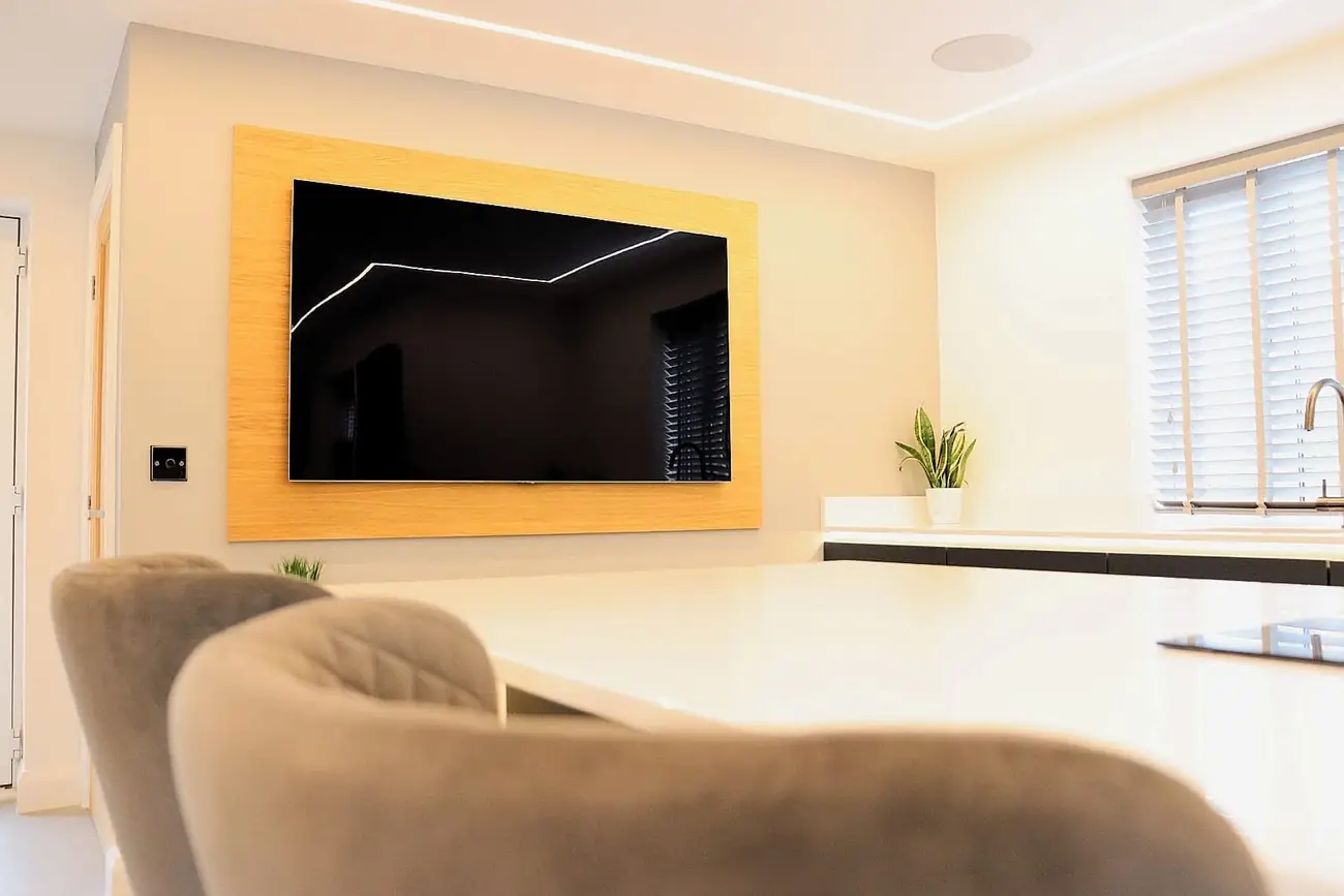 Oak-framed wall-mounted TV above dark media cabinetry